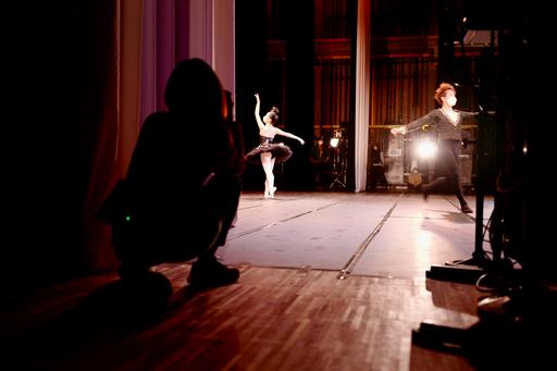 A person watching two ballet dancers from backstage